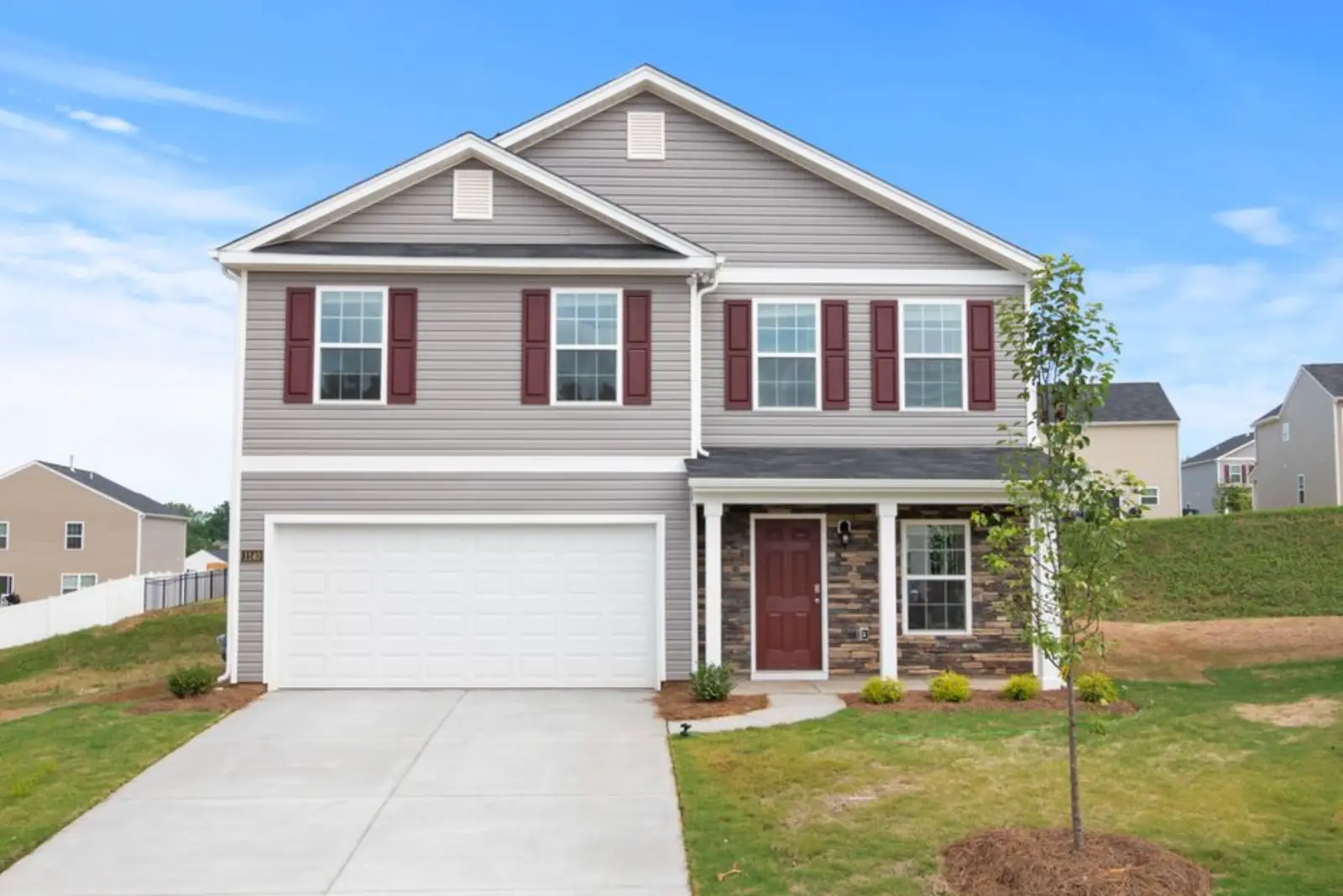 A modern suburban house with a neatly landscaped front yard and driveway.